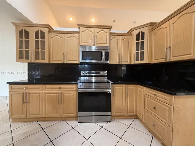 a kitchen with stainless steel appliances granite countertop a stove a sink and a granite counter tops
