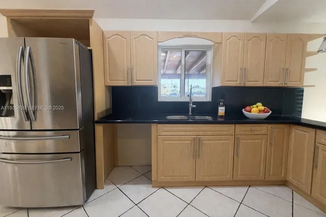 a kitchen with stainless steel appliances granite countertop a refrigerator and a sink