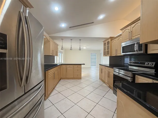 a kitchen with stainless steel appliances granite countertop a refrigerator and a stove