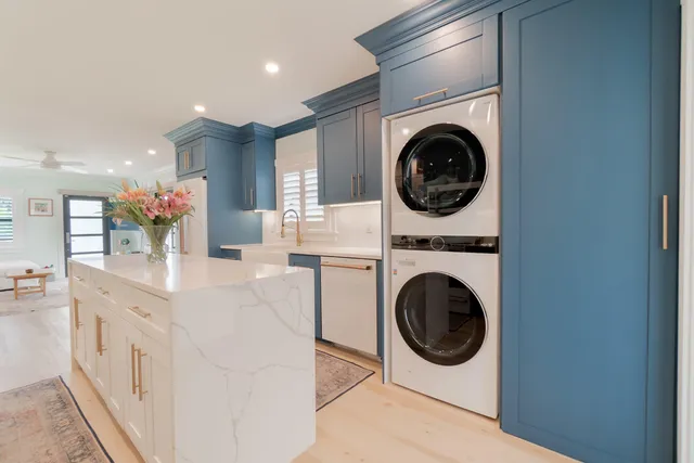 a kitchen with a sink and a stove top oven with wooden floor