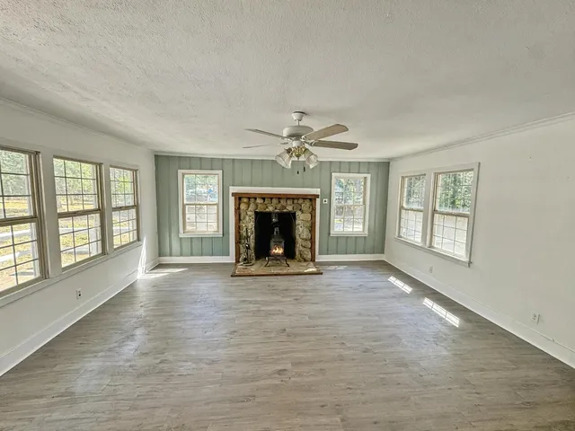 a view of an empty room with window and fire place