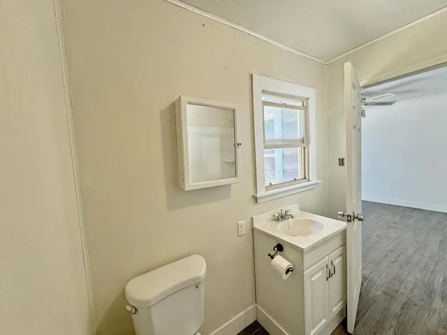 a bathroom with a sink a toilet and a mirror
