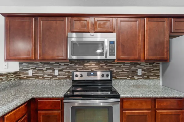 a kitchen with granite countertop stainless steel appliances and cabinets