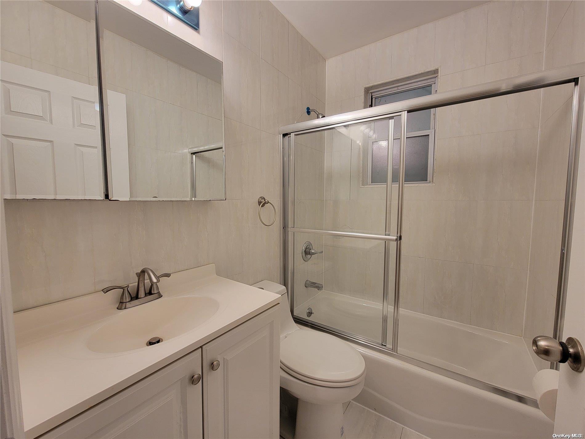 85-30 79th Street Queens, NY 11421 - Photo 13 of 23 a bathroom with a sink mirror bathtub and toilet
