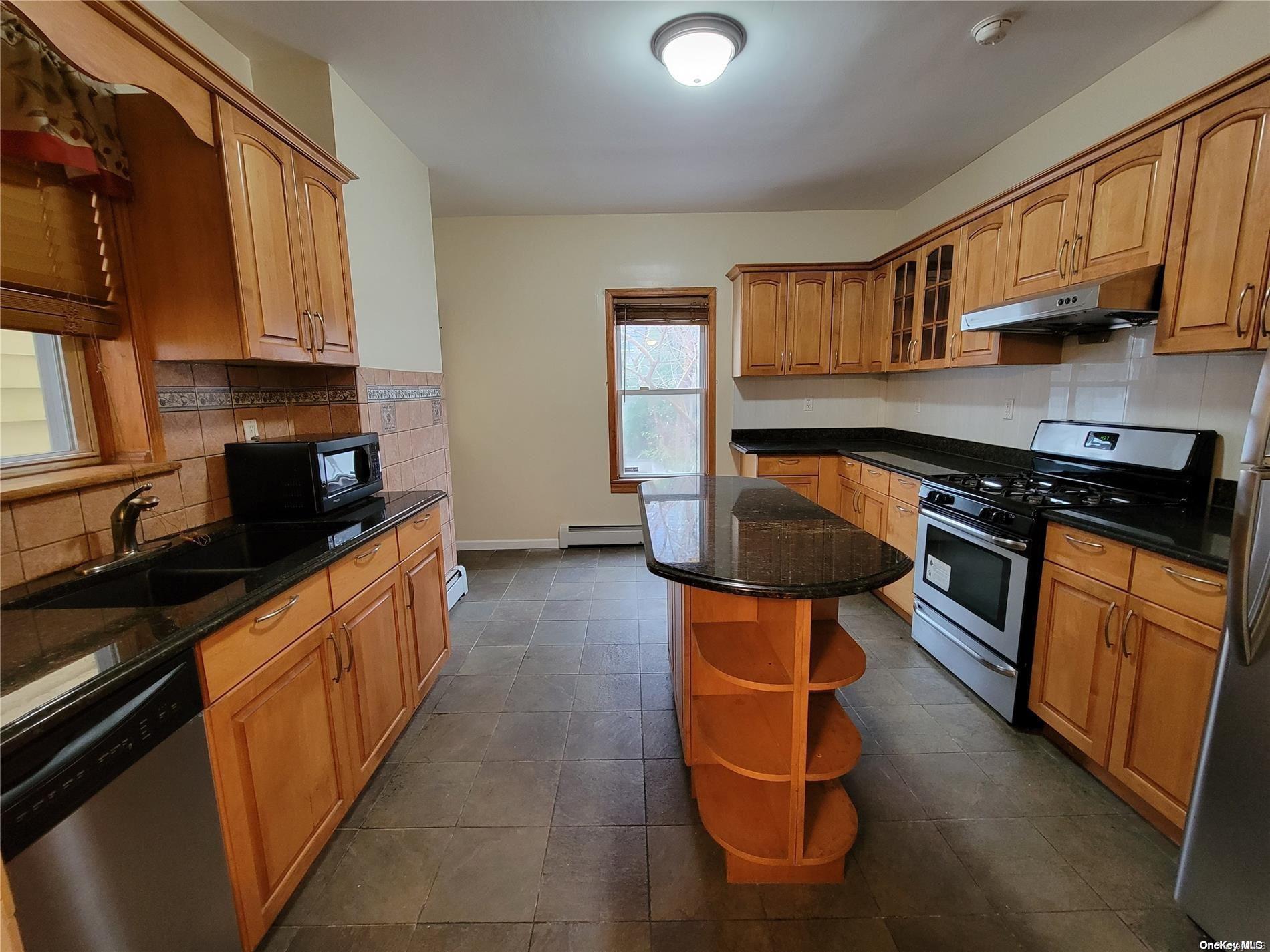 85-30 79th Street Queens, NY 11421 - Photo 14 of 23 a kitchen with stainless steel appliances granite countertop a stove a sink and a refrigerator
