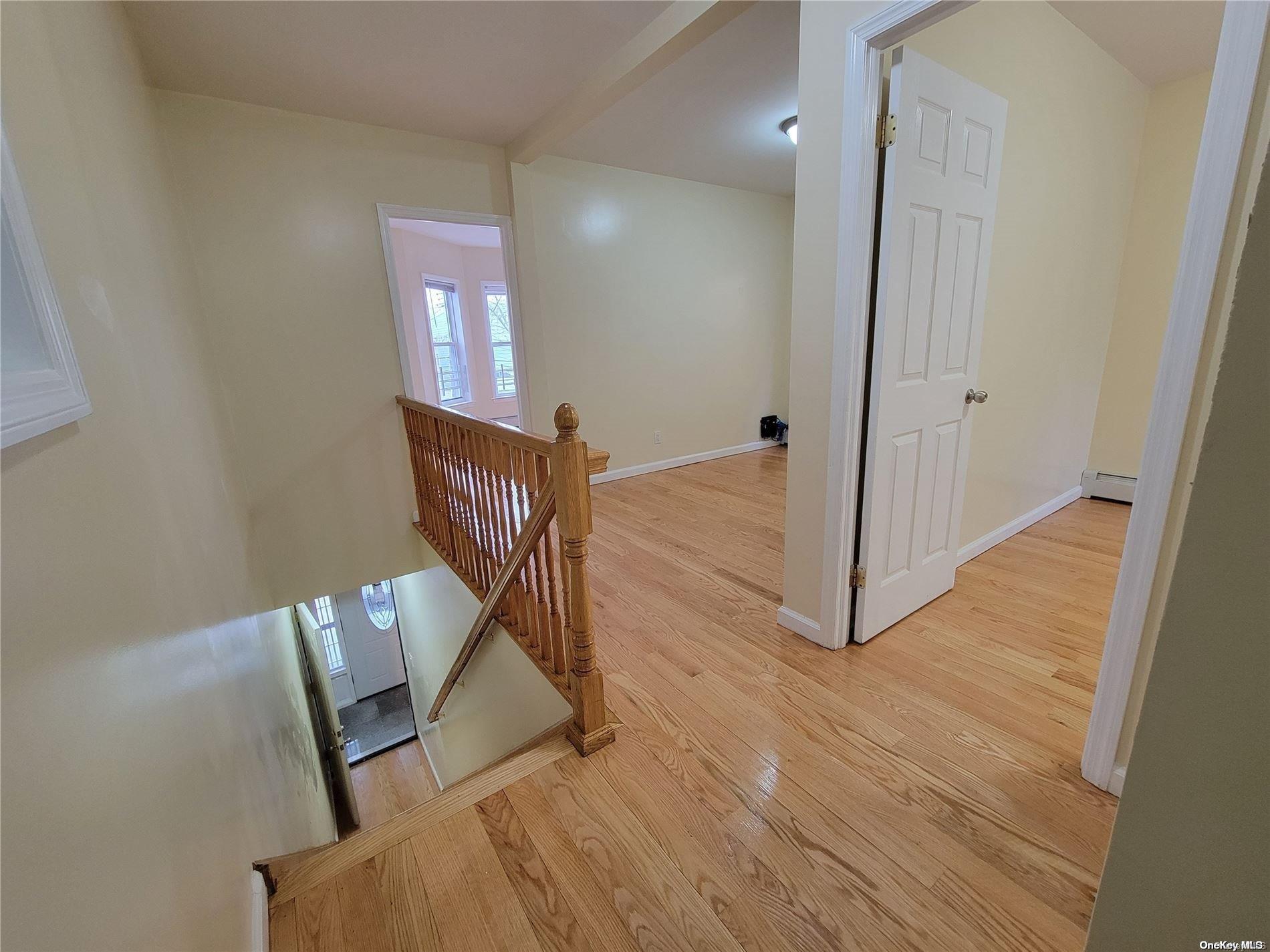 85-30 79th Street Queens, NY 11421 - Photo 6 of 23 a view of a hallway with wooden floor and stairs