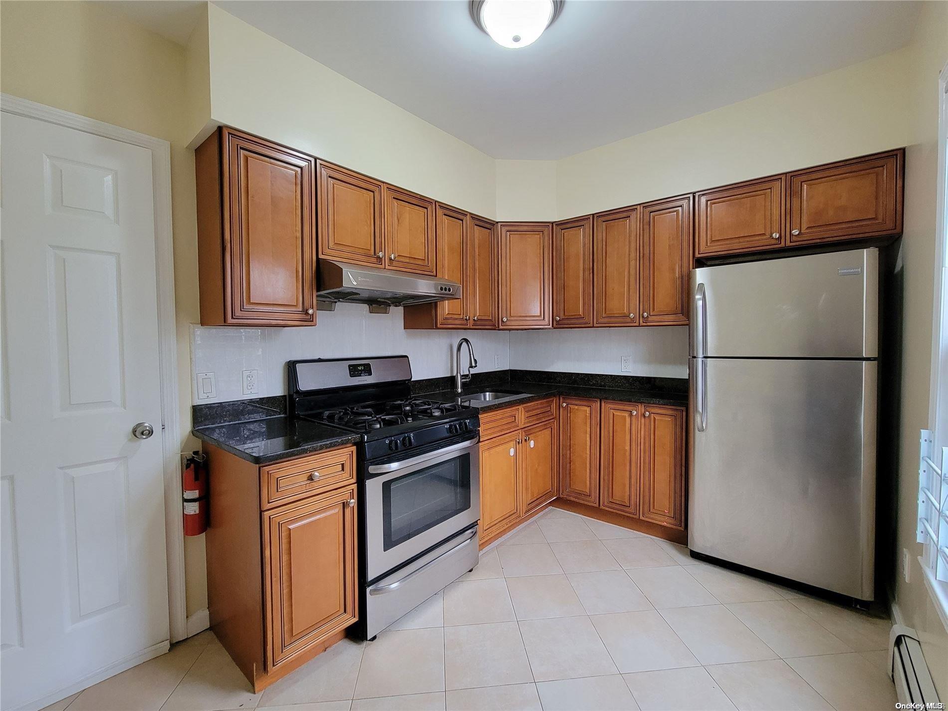 85-30 79th Street Queens, NY 11421 - Photo 9 of 23 a kitchen with granite countertop a refrigerator and a stove top oven