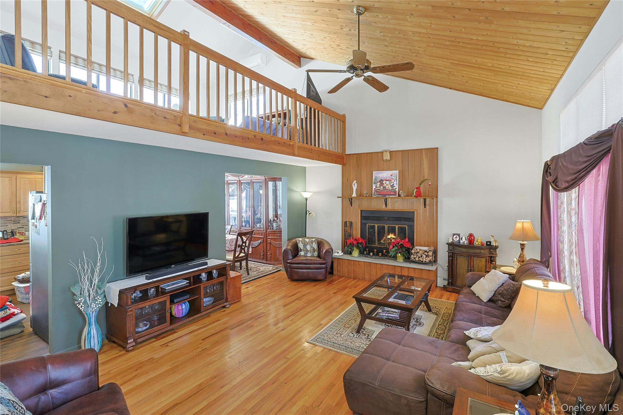 31 Powder Horn Road Cortlandt Manor, NY 10567 - Photo 2 of 36 Living area featuring wood finished floors, a fireplace, a wood ceiling with exposed beams, and high vaulted ceiling