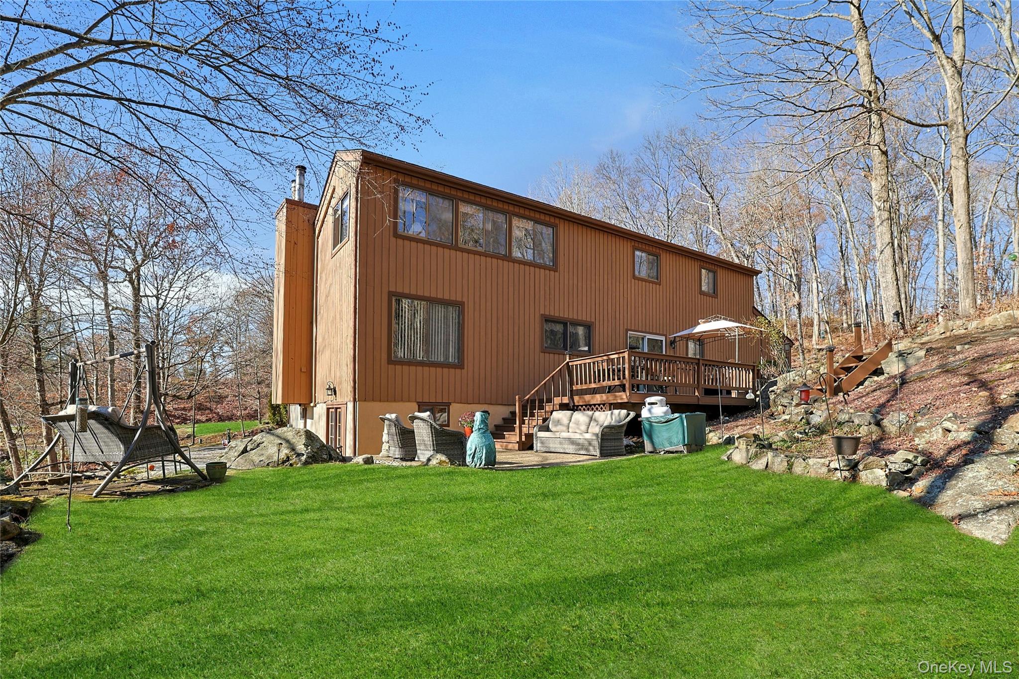 31 Powder Horn Road Cortlandt Manor, NY 10567 - Photo 27 of 36 Rear view of property featuring a yard, a wooden deck, and a chimney