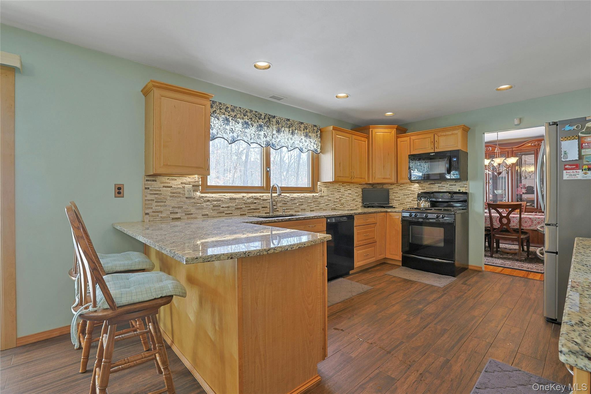 31 Powder Horn Road Cortlandt Manor, NY 10567 - Photo 9 of 38 a kitchen with granite countertop a stove top oven a sink dishwasher a dining table and chairs with wooden floor