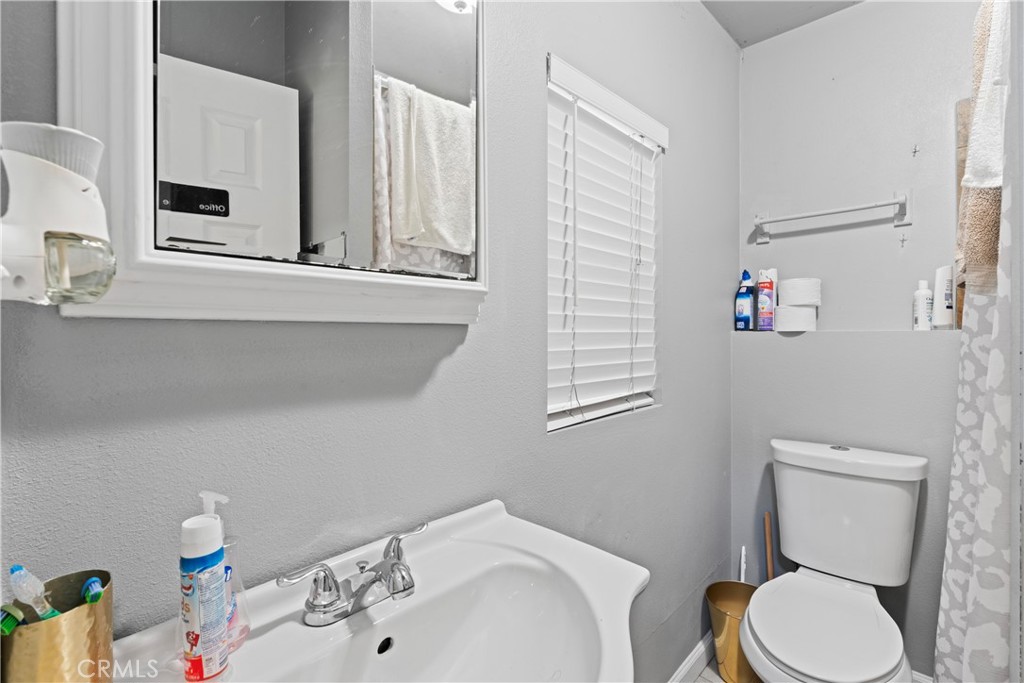 1286 Lovers Lane Rimforest, CA 92378 - Photo 17 of 27 a bathroom with a toilet sink and mirror