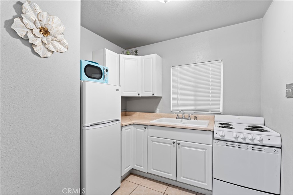 1286 Lovers Lane Rimforest, CA 92378 - Photo 10 of 27 a kitchen with a white cabinets sink and white appliances
