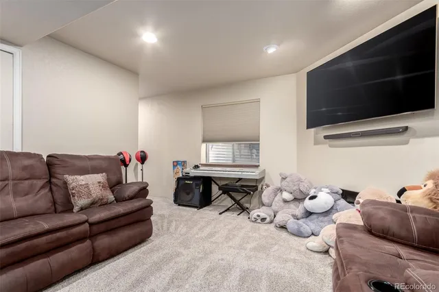 a living room with furniture a flat screen tv and kitchen view