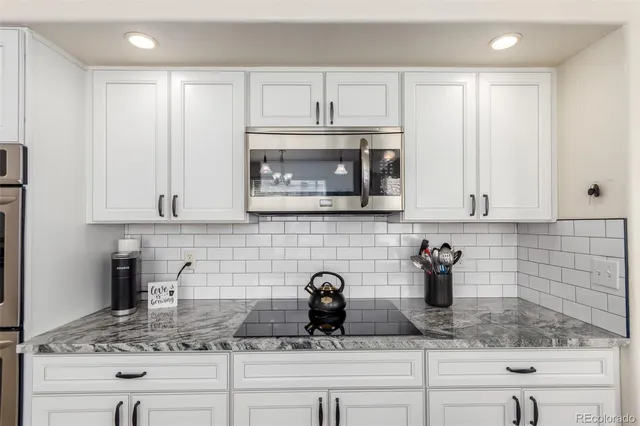 a kitchen with appliances a sink and cabinets