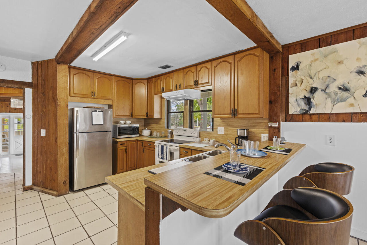 14601 Orange Avenue Fort Pierce, FL 34945 - Photo 13 of 37 a kitchen with stainless steel appliances kitchen island granite countertop a sink a stove and refrigerator