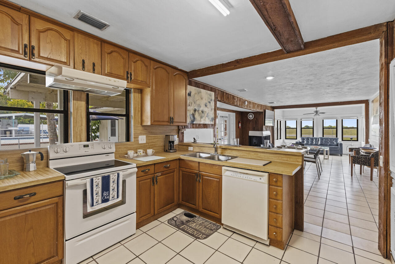 14601 Orange Avenue Fort Pierce, FL 34945 - Photo 15 of 37 a kitchen with stainless steel appliances granite countertop a stove and more cabinets