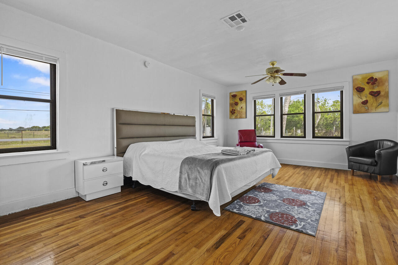 14601 Orange Avenue Fort Pierce, FL 34945 - Photo 18 of 37 a bedroom with a bed and wooden floor