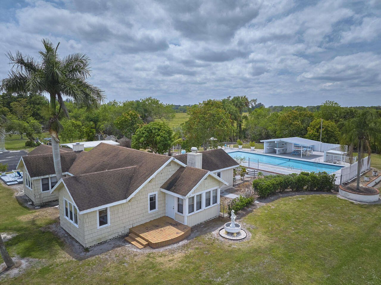 14601 Orange Avenue Fort Pierce, FL 34945 - Photo 4 of 37 a view of a patio with table and chairs potted plants and a big yard