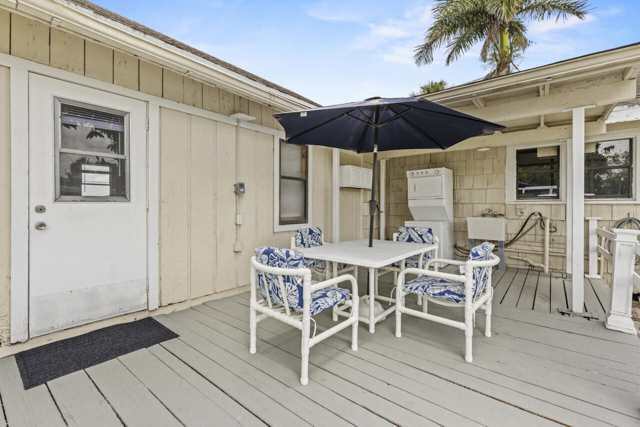 14601 Orange Avenue Fort Pierce, FL 34945 - Photo 7 of 37 a view of a patio with table and chairs under an umbrella with wooden floor