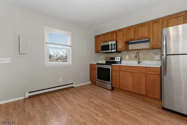 a kitchen with stainless steel appliances granite countertop a stove top oven a sink and a refrigerator