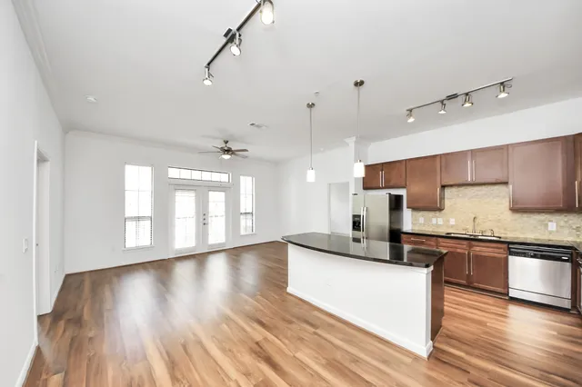 a large kitchen with stainless steel appliances granite countertop a stove a sink and a refrigerator