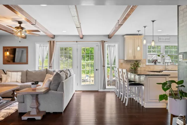a living room with furniture a wooden floor and a chandelier