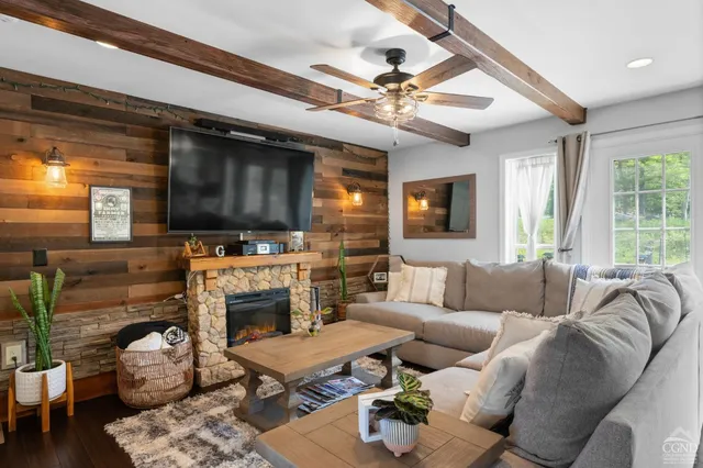 a living room with furniture a flat screen tv and a fireplace