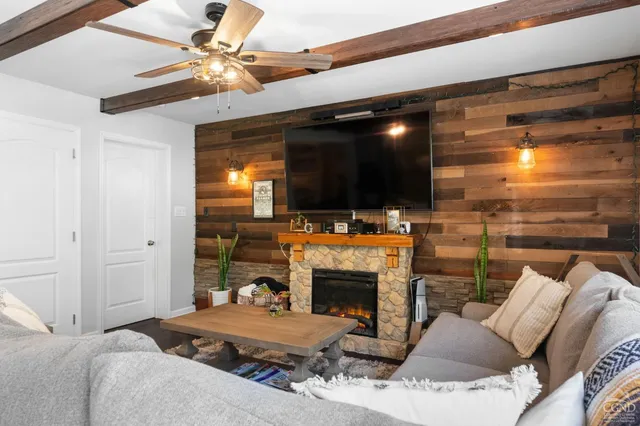 a living room with furniture a flat screen tv and a fireplace