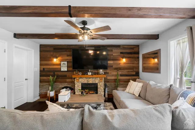 a living room with furniture a flat screen tv and a fireplace