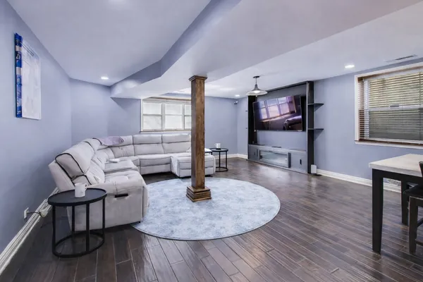 a living room with furniture and a wooden floor