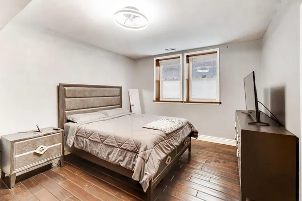 a bedroom with a bed and wooden floor