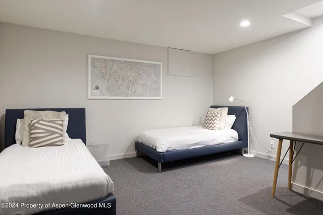 a bedroom with a bed and a lamp with the dresser