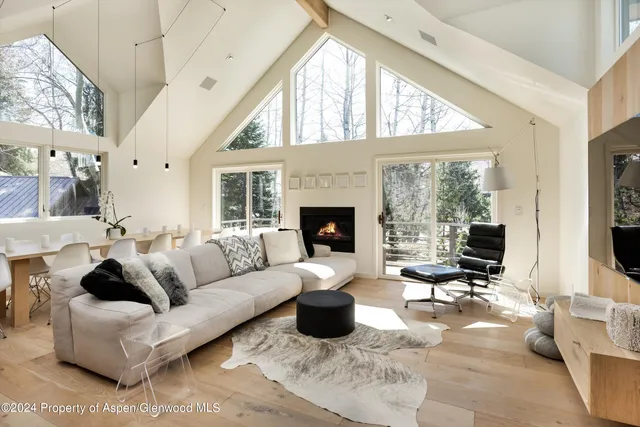 a living room with furniture large window and a fireplace