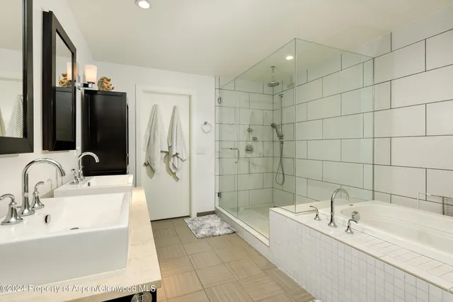 a bathroom with a tub sink and mirror