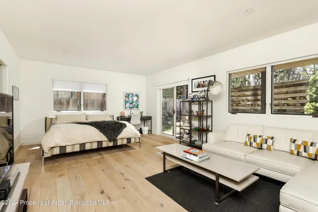 a living room with furniture and large window with garden view