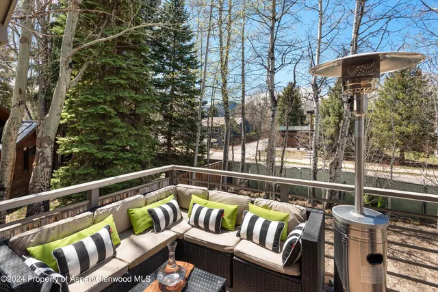 a roof deck with couches and wooden floor