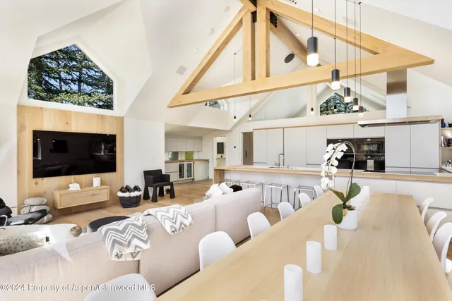 a living room with furniture a flat screen tv and kitchen view
