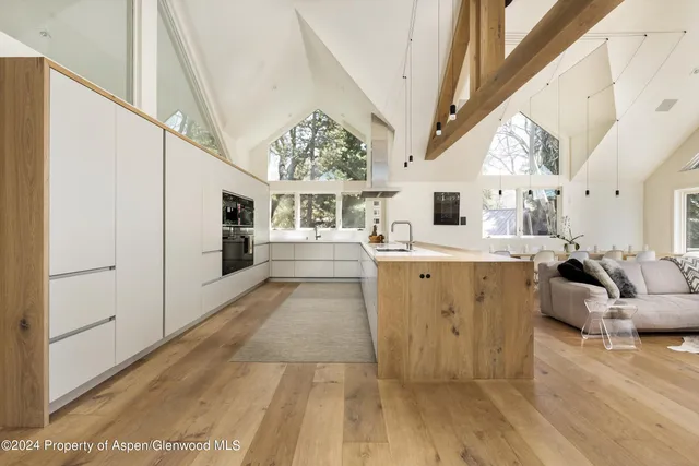 a view of living room kitchen with stainless steel appliances kitchen island hardwood floor and living room view