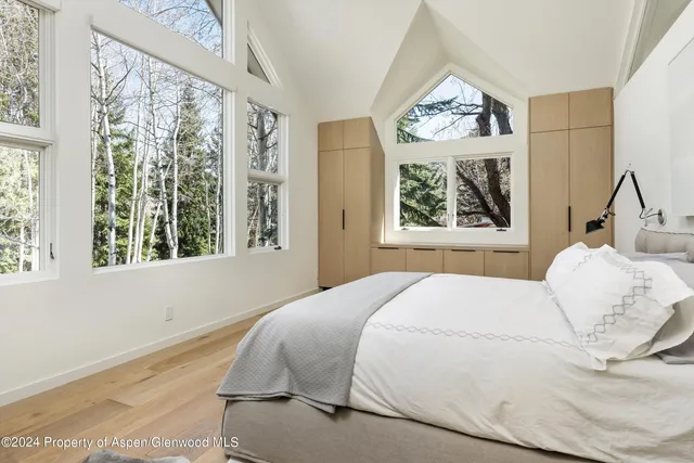 a bedroom with a bed and a large window