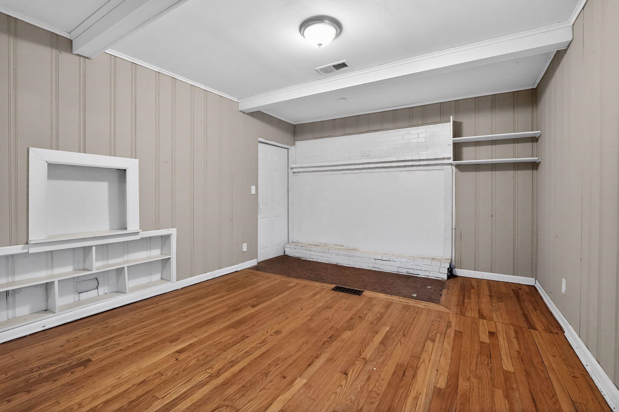 4094 Auburn Road Memphis, TN 38116 - Photo 18 of 30 Unfurnished bedroom with hardwood / wood-style flooring, beamed ceiling, and wooden walls