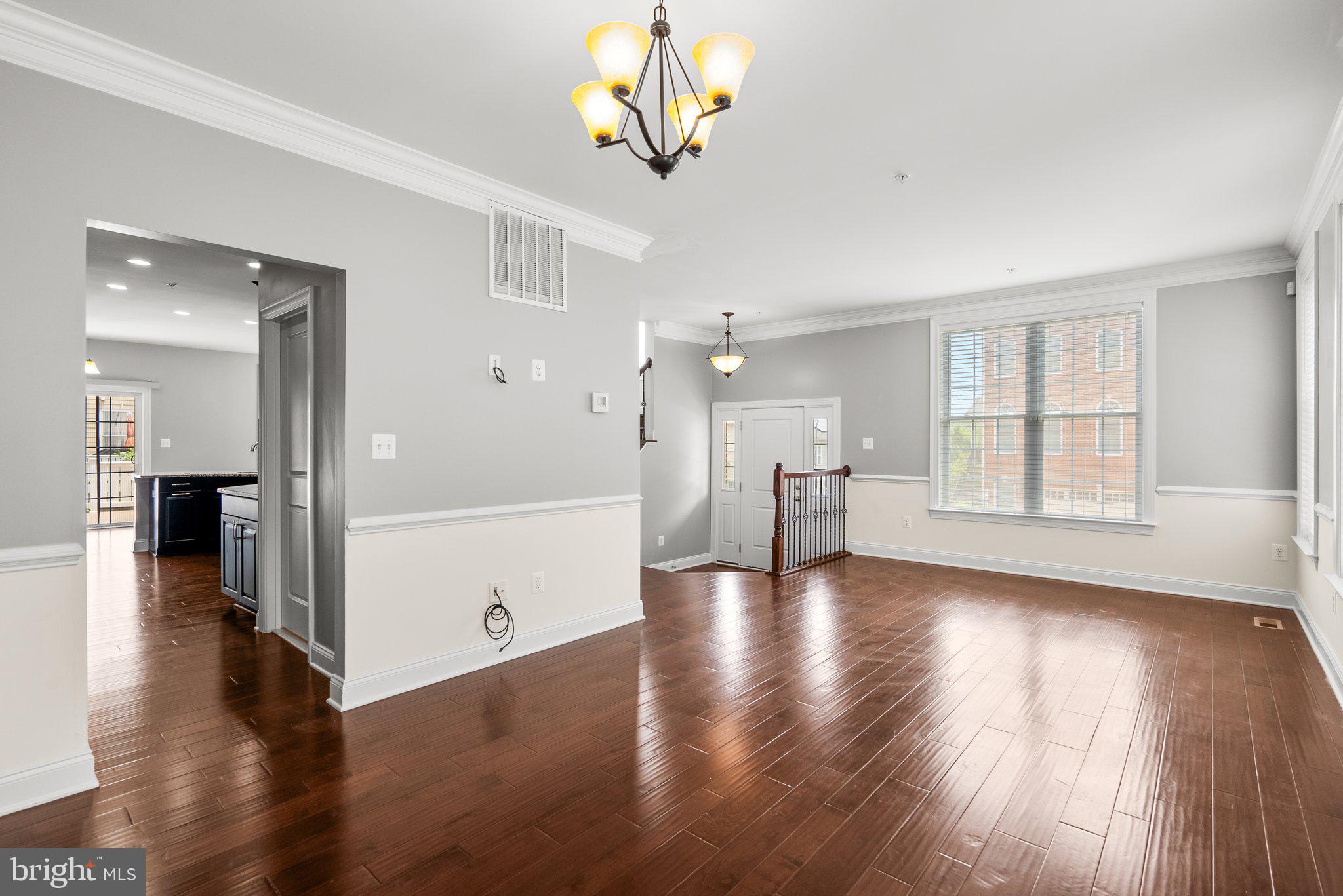 2501 Cherry Tree Road Hanover, MD 21076 - Photo 6 of 30 a view of a kitchen and an empty room with wooden floor and a kitchen