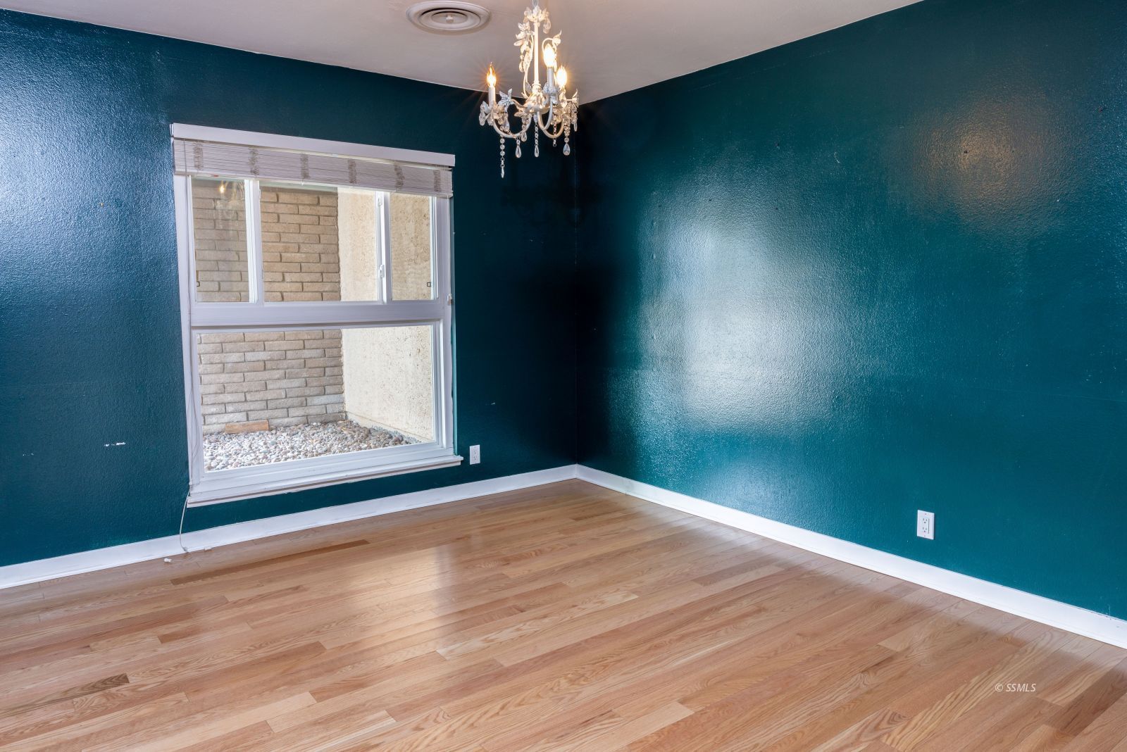 921 North Sierra View Street Ridgecrest, CA 93555 - Photo 11 of 27 a view of an empty room with wooden floor and a window