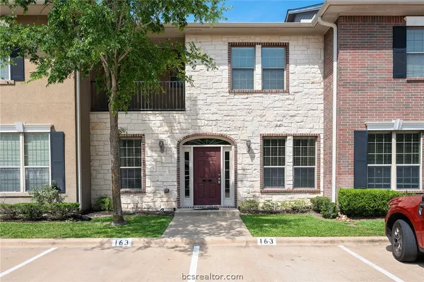 a front view of a house with a garden and plants