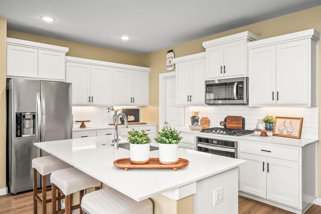 4017 Mapleleaf Pass Melissa, TX 75454 - Photo 3 of 32 a kitchen with white cabinets and stainless steel appliances