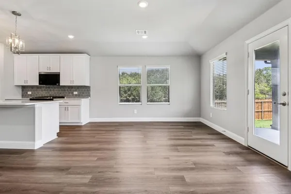 a view of kitchen with microwave stove oven and cabinets