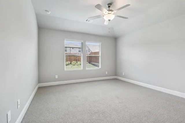 an empty room with a window and a fan