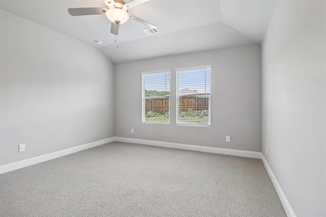an empty room with a window and a ceiling fan