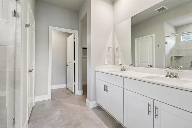 a bathroom with double sink and a mirror