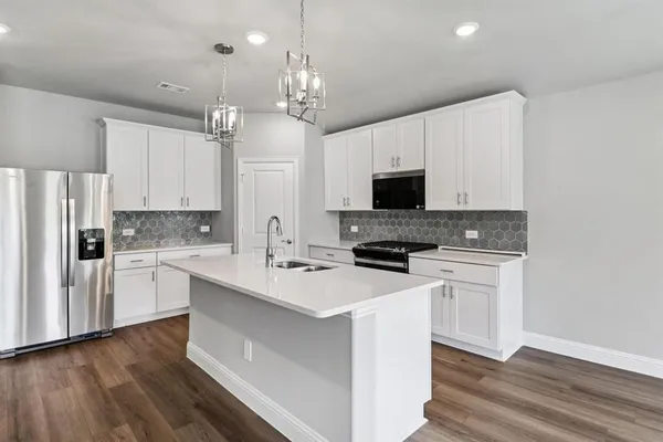 a kitchen with a stove a sink and a refrigerator