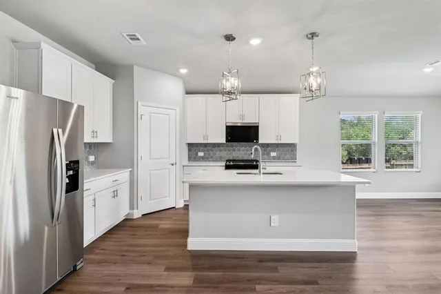 a kitchen with kitchen island white cabinets and stainless steel appliances
